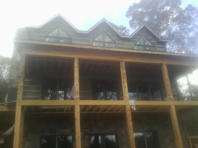Dormers and porch framing on a large log home under construction — Roof Coating work by our crew in Desoto
