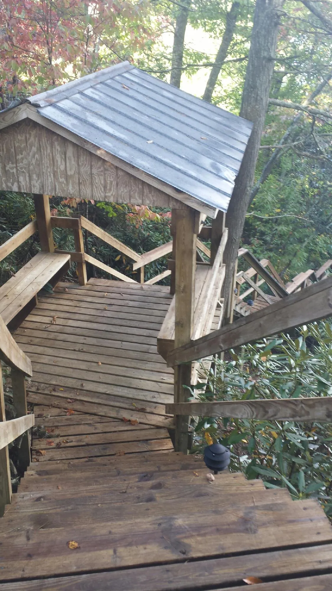 Metal roofed shelter over wooden steps on a wooded walkway — Skylight Repair & Installation work by our crew in Desoto