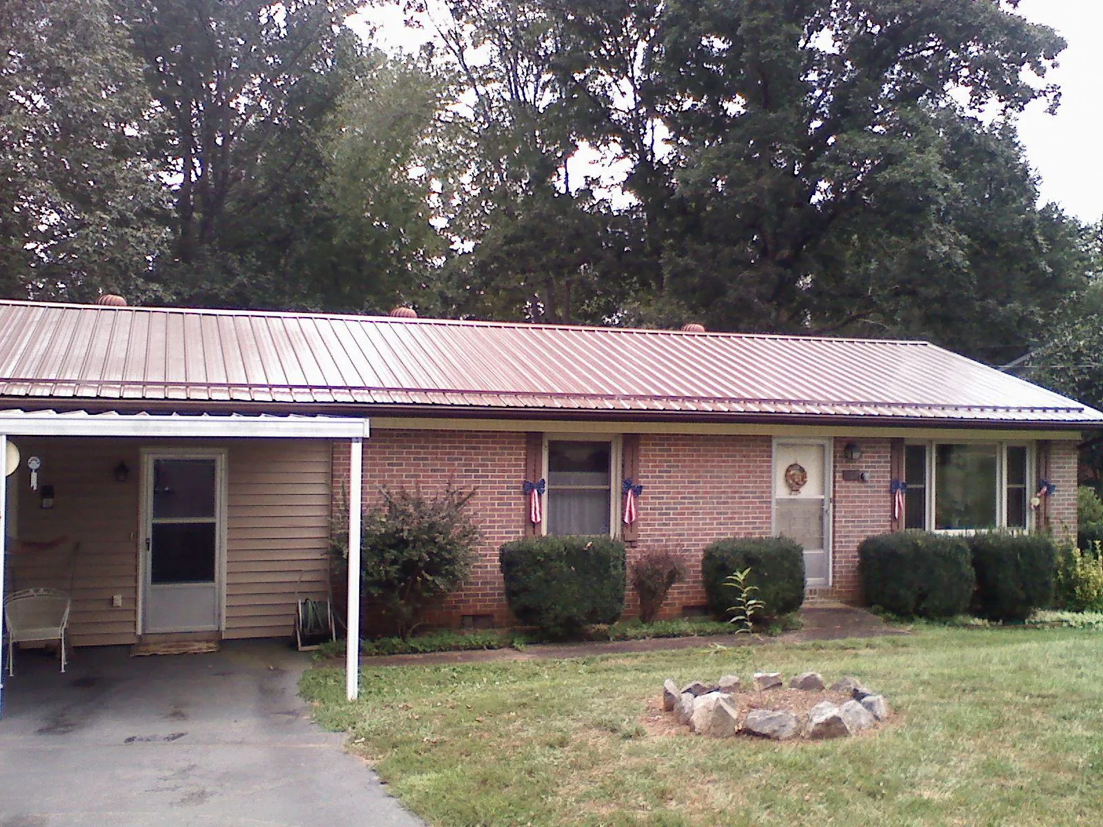 Bronze metal roof and carport on a brick ranch home — Roof Repair work by our crew in Desoto